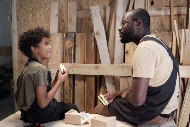 istock Father and Son Eating Snacks in Workshop 1371721552