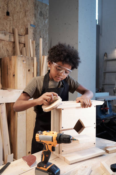 little boy building vogelhaus - carpenter carpentry craft skill stock-fotos und bilder