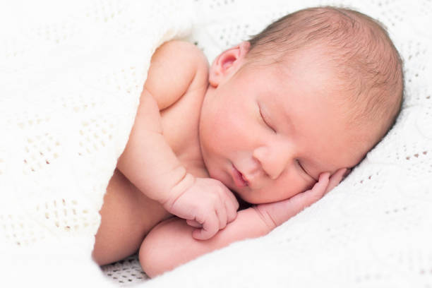 istock newborn baby sleeps and smiles. 1371722065