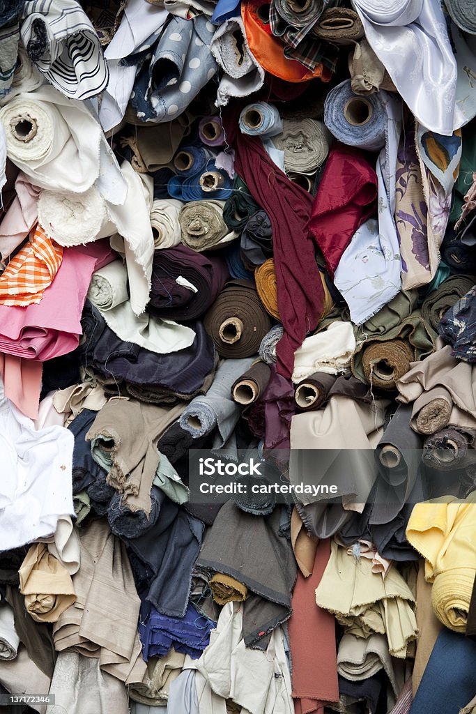 Bolts of fabric at a flea market stall Stacks and piles of fabric and bolts of material at a street market.  Check out my GARAGE SALES, STREET AND FLEA MARKETS Lightbox or see some sample images below: 2000-2009 Stock Photo