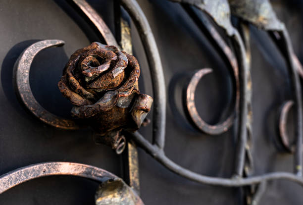 Metal wrought rose, in rust. Decorative elements of the gate