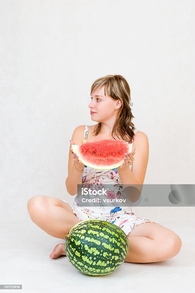 Girl with a slice of water melon A sitting girl with a water melon in her hands Adolescence Stock Photo