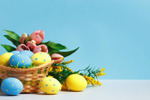 istock Easter concept. Basket of eggs flowers on a blue background copy space. 1371729274
