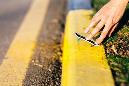 A few simple tricks on a skateboard with two fingers close-up.