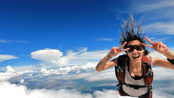 imagen de una mujer paracaidista con ropa casual sonriendo - deporte de alto riesgo fotografías e imágenes de stock