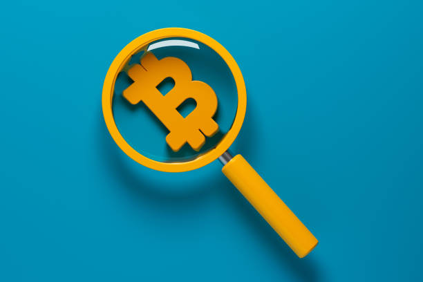 istock Orange-colored magnifying glass and orange-colored bitcoin coin symbol. 1371737456