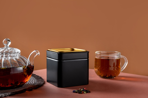 Embalaje de metal negro para té. Maqueta de marca y empaque de té. Maqueta de empaque de té en blanco con té para mostrar su diseño de marca. photo