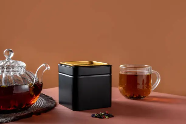 Photo of Black metal packaging for tea. Tea branding and packaging mockup. Blank tea packaging mockup with tea to display your branding design.