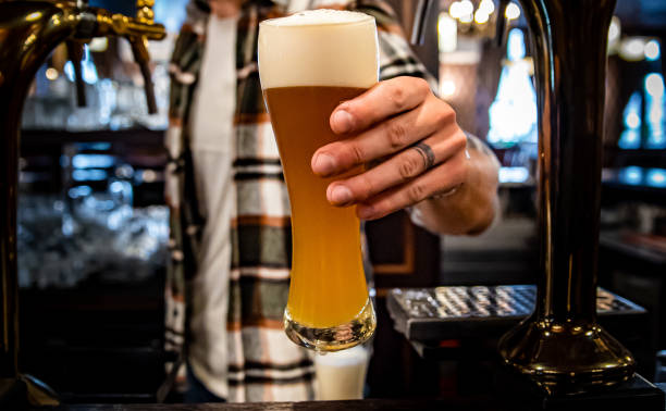 istock bartender pouring a draught beer in glass serving in a bar or pub 1371745254