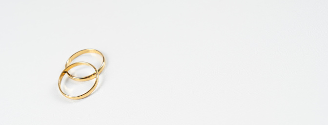 Gold wedding rings on a white background with copy space