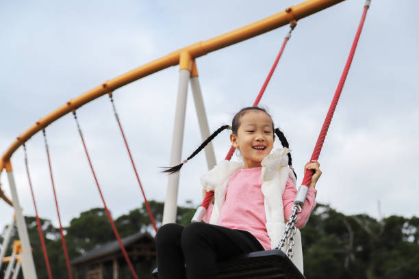 istock girls playing swing. 1371750480