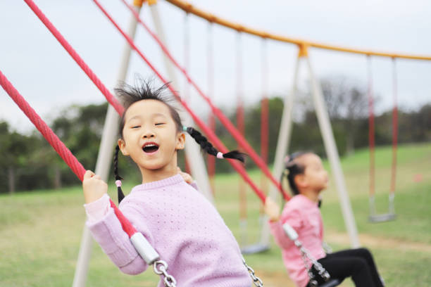 istock girls playing swing. 1371750539