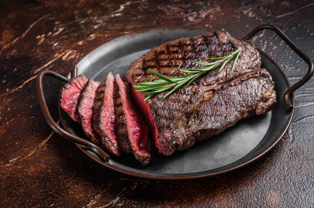 グリルミディアムレアトップサーロインビーフステーキまたはランプステーキをスチールトレイに。暗い背景。トップビュー - sirloin steak 写真 ストックフォトと画像