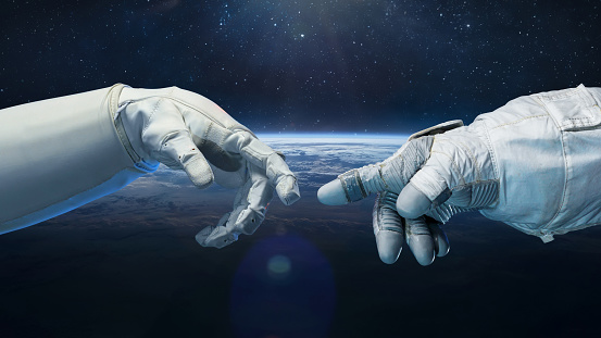 Astronaut in glove and robot hands in space. Earth planet on background. Technology and space flight. Elements of this image furnished by NASA (url: https://www.nasa.gov/sites/default/files/styles/full_width_feature/public/thumbnails/image/iss063e074377.jpg https://www.nasa.gov/sites/default/files/images/629739main_jsc2010e188611_226.jpg)