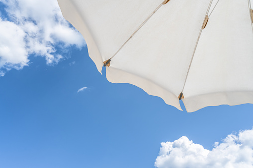 Beach umbrella against blue morning sky.