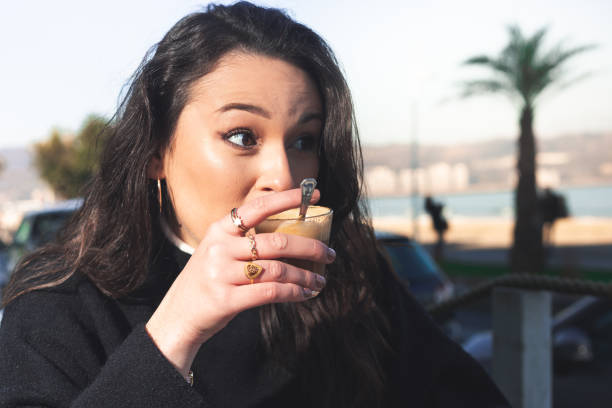 istock Young caucasian woman taking a break with a coffee and croisant at a terrace. 1371753688