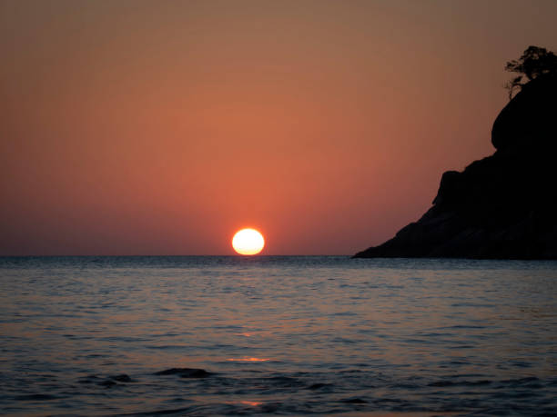 Golden sunset time with reflection and island silhouette. Wonderful time at Phuket, Thailand.