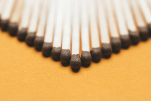 Heap of matches with brown heads on yellow background.