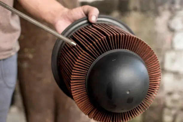A mechanic cleans the air filter of a diesel engine with a compressed air blower gun.