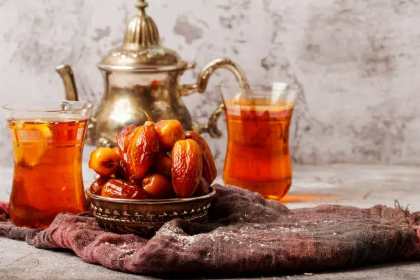 Traditional Turkish delight with Turkish tea on gray background. Ramadan Kareem celebration concept. Fragrant Turkish tea and Turkish sweets in national dishes.