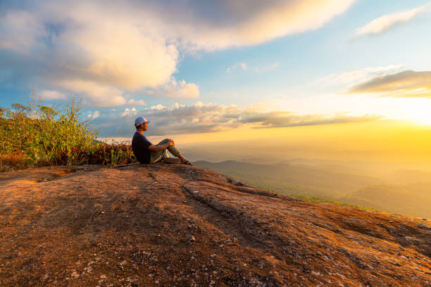istock man sitting on the cliff 1371762166