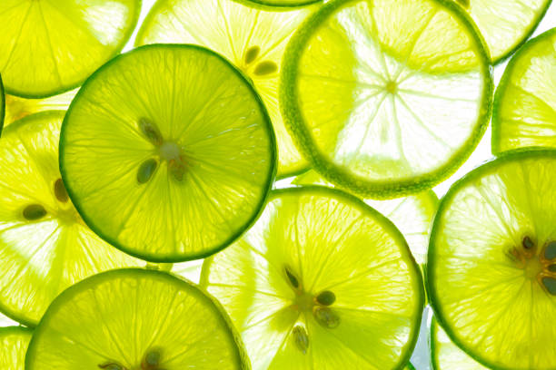 macro limão, limão e limão verde sobrepõem fatias de close-up fundo, textura de limão macro, textura macro close up superfície fatia suculenta de limão - lemon textured peel portion - fotografias e filmes do acervo