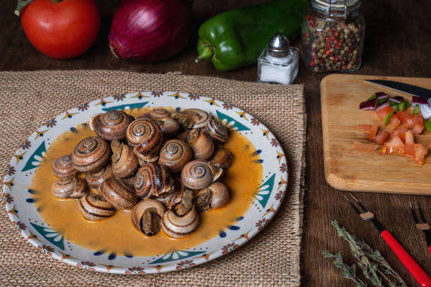 istock Snail stew, dish based on a sauce of vegetables and cooked snails. 1371763551