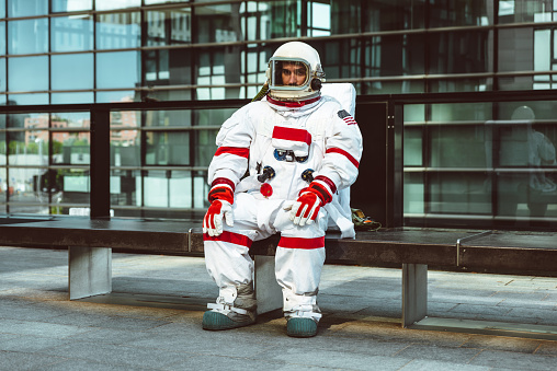 spaceman in a futuristic station. astronaut with space suit walking in an urban area
