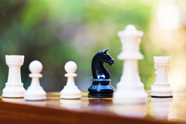 istock Lone black knight deep in white territory on a chessboard 1371767527