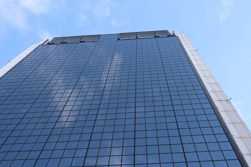 Genova, Italy-January 29, 2022: Beautiful modern high-rise buildings against the sky. 3d illustration on the theme of business success and technology. clouds reflection on the mirror.Industrial zone.