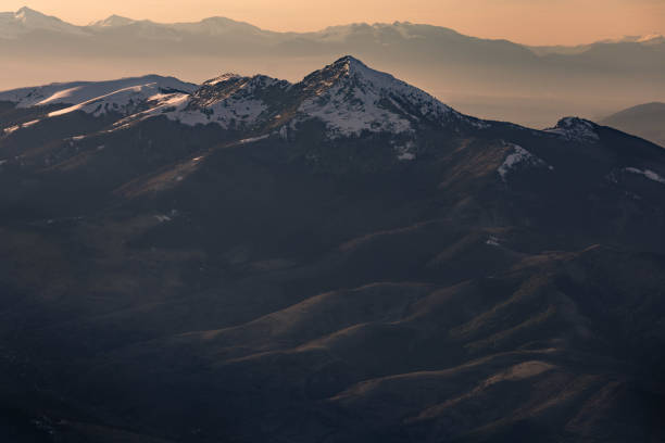 istock Setting sun falls on the mountain tops covered in snow 1371773727
