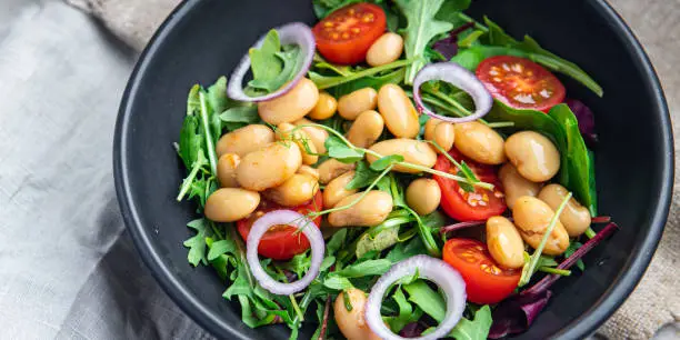 salad white beans, tomato, leaves lettuce mix petals fresh portion healthy meal food diet snack on the table copy space food background