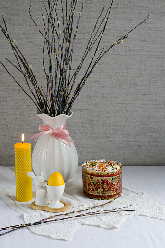 Easter card. Willow branches, a yellow wax candle, an Easter festive cake and a painted egg. Banner. Minimal concept. Copy space for text.