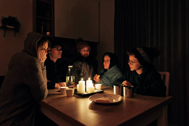 Family sitting by the candles during the blackout. stock photo