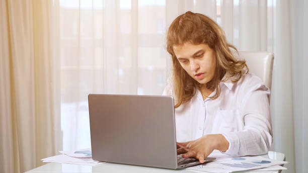 istock Disabled woman freelancer works on laptop from home at table 1371779854