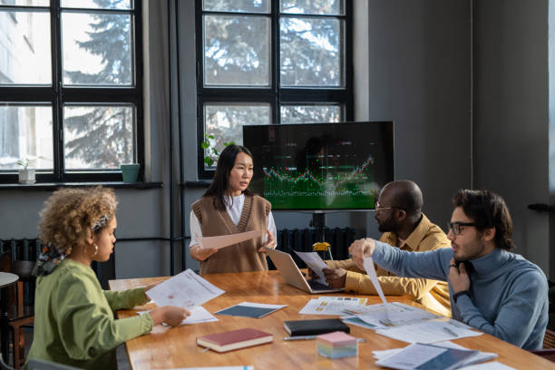 istock Young Asian female economist with document making presentation 1371781585
