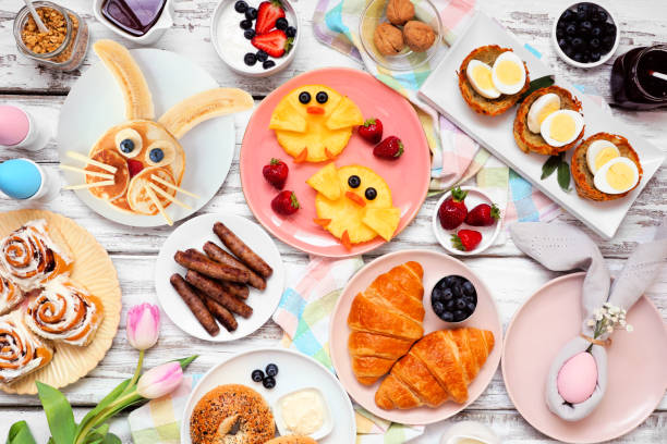 Easter breakfast or brunch table scene. Top view on a white wood background. Easter breakfast or brunch table scene. Top view on a white wood background. Bunny pancake, egg nests, chick fruit and a collection of spring food items. Copy space. bunny pancake stock pictures, royalty-free photos & images