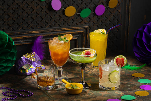 coquetéis alcoólicos, decoração de mardi gras em fundo escuro - hurricane cocktail - fotografias e filmes do acervo