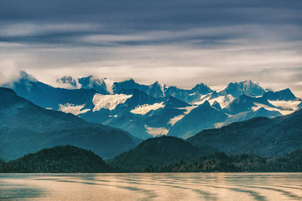 Alaska mountains range snow capped peaks in inside passage, Glacier bay nature landscape at autumn sunset dusk. View from cruise ship travel.