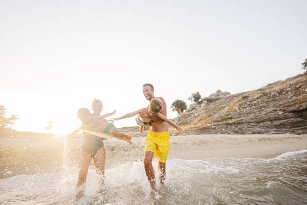 istock Smiling boys with parents at the beach 1371787024