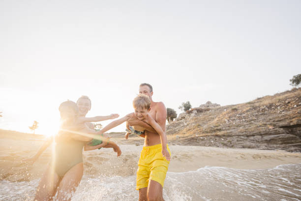 istock Smiling boys with parents at the beach 1371787107