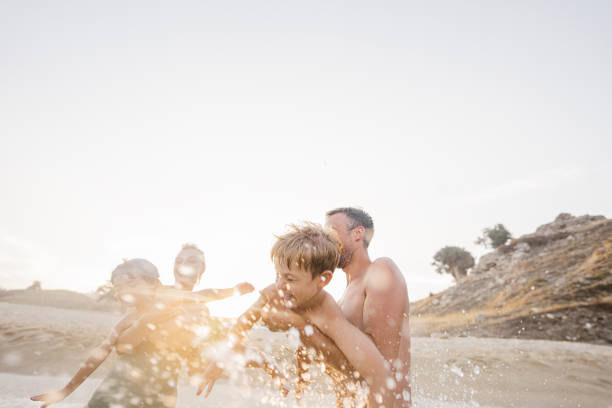 Photo of smiling boys with parents at the beach