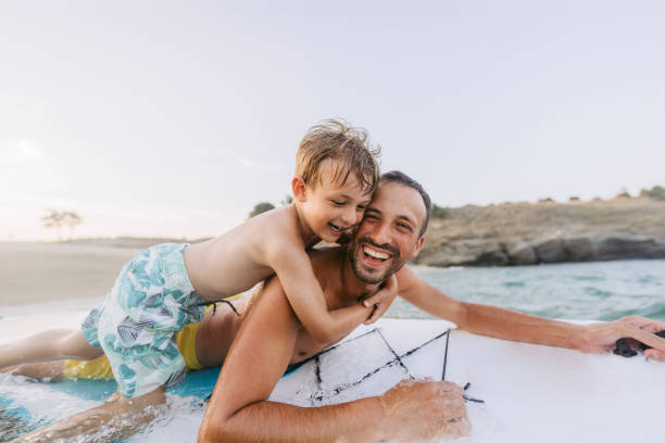 partner per avventure divertenti - surfing beach family father foto e immagini stock