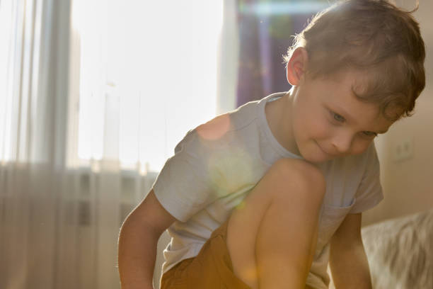 istock Funny boy 4-5 years old playing with a room flooded with sunlight. 1371788728
