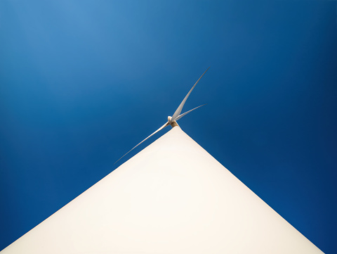 Wind generator for producing clean ecologic energy. Minimalistic bottom view with extreme dramatic perspective