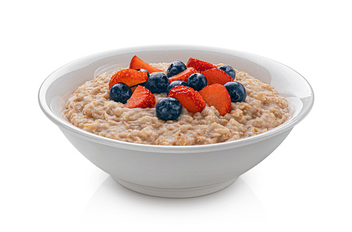 Bowl of oatmeal with berries isolated on white background, healthy oat porridge breakfast