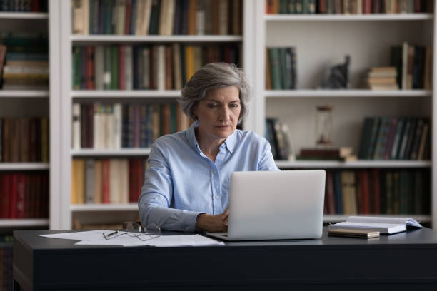 istock Thoughtful old businesswoman working remotely on computer. 1371790983