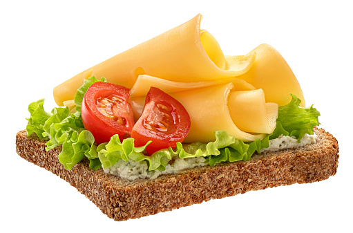 Gouda cheese slices on rye bread with tomatoes and lettuce leaves isolated on white background, top view
