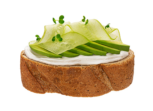Rye toasted bread with cream cheese, avocado and cucumber, vegetarian sandwich isolated