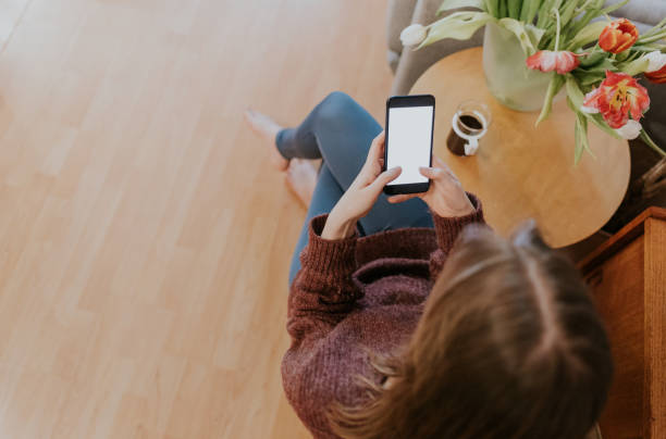 istock Young woman drinking coffee and using smartphone 1371794435